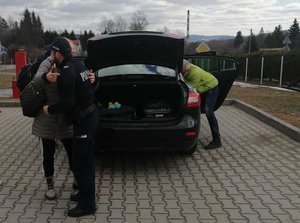 kobieta dziękuje policjantowi, w tle samochód z otwartymi drzwiami