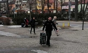 Policjant pomaga niosąc walizkę