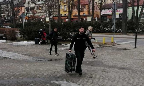 Policjant pomaga niosąc walizkę