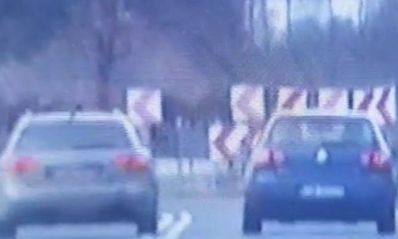 dwa samochody jadące drogą