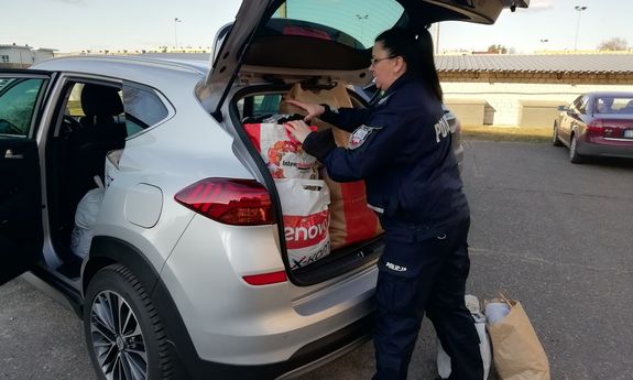 policjantka  pakuje do samochodu torby z przekazanymi rzeczami od policjantów dla ukraińskich rodzin