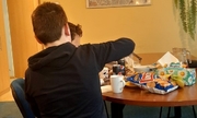 dwóch ukraińskich chłopców siedzących przy stole w komisariacie spożywających posiłek
