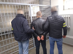 dwaj policjanci z zatrzymanym mężczyzną