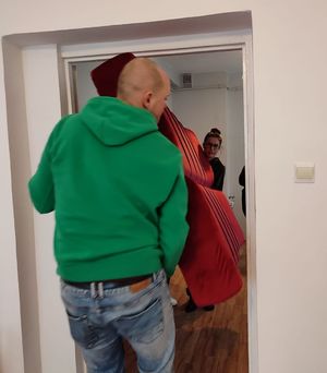 Kobieta i mężczyzna wnoszą kanapę do pokoju przez drzwi