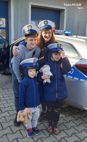 Matka z dziećmi w czapkach policyjnych