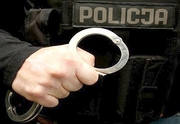 policjant trzymający w dłoni kajdanki