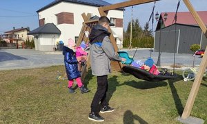 na fotografii dzieci bawiące się na placu zabaw na podwórku policjanta