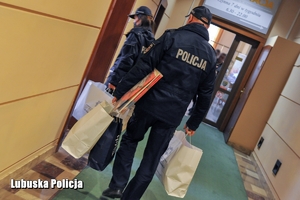 Policjanci niosą akcesoria profilaktyczne dla dzieci