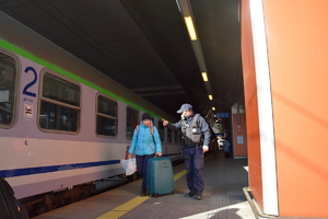 Policjant wskazuje kobiecie drogę do pociągu