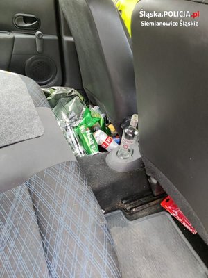 puste butelki i puszki po alkoholu za fotelem kierowcy