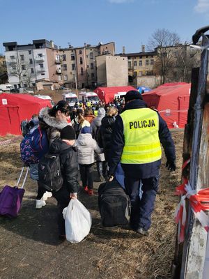 Policjant pomaga ukraińskiej rodzinie z bagażem