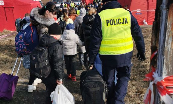 Policjant pomaga ukraińskiej rodzinie z bagażem