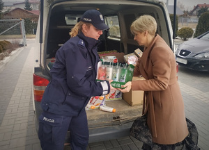 policjantka wraz z panią dyrektor Caritas w Krasnymstawie wypakowują towar z pojazdu