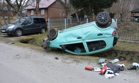 W przydrożnym rowie znajduje się samochód, który odwrócony jest na dach. Obok tego pojazdu znajdują się różne rzeczy które wypadły z samochodu