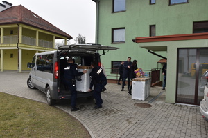 policjanci wynoszą pralkę z samochodu