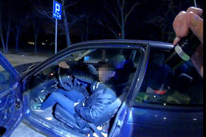 kierujący siedzi w BMW, drzwi auta są otwarte