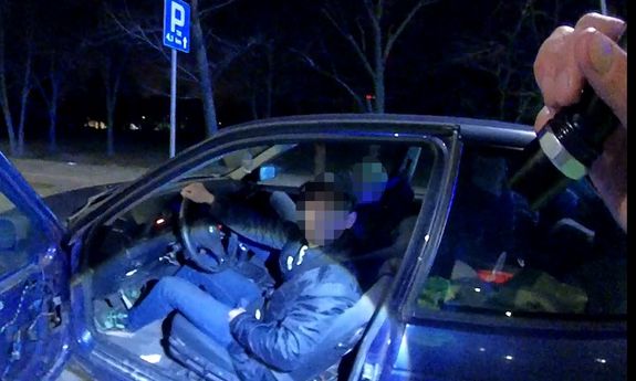 kierujący siedzi w BMW, drzwi auta są otwarte