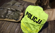 Policjantka w żółtej kamizelce obok ułożone worki z marihuaną