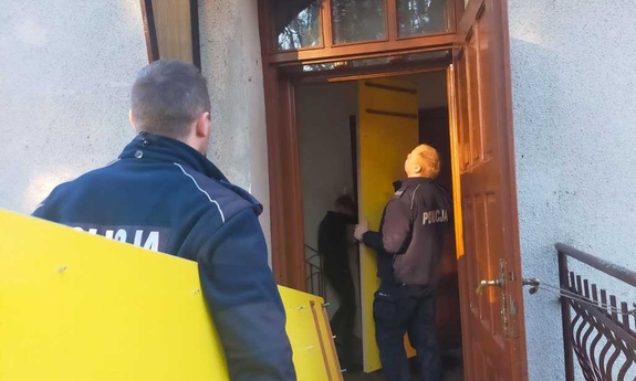 policjanci wnoszą elementy szafy do budynku