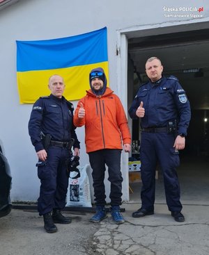 policjanci z mężczyzną przy fladze Ukrainy
