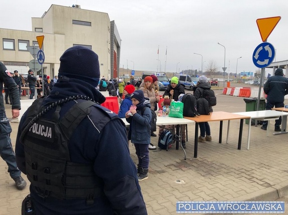 policjant stoi przy przejściu granicznym