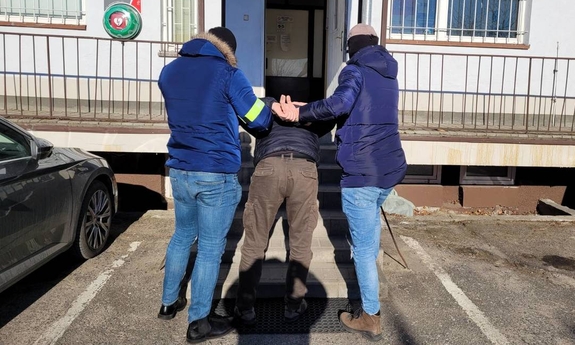 dwaj nieumundurowani policjanci prowadzą zatrzymanego