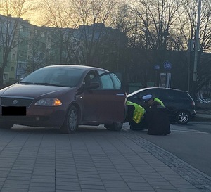 Policjanci naprawiają samochód kobiety