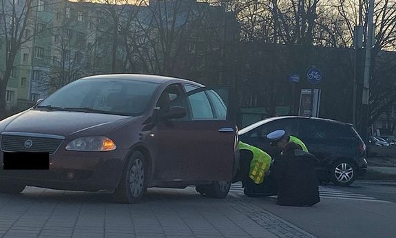 Policjanci naprawiają samochód kobiety