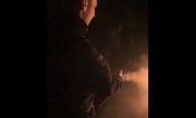Na zdjęciu noc policjant gasi pożar gaśnicą