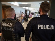 dwaj policjanci przy punkcie informacyjnym podczas składania wniosków o nadanie numeru pesel dla uchodźców
