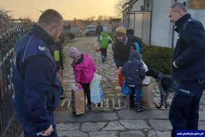 Policjanci podczas spotkania z uchodźcami w powiecie braniewskim. Dzieci odebrały przekazane im podarki