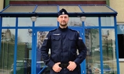 policjant stoi przed budynkiem jednostki Policji
