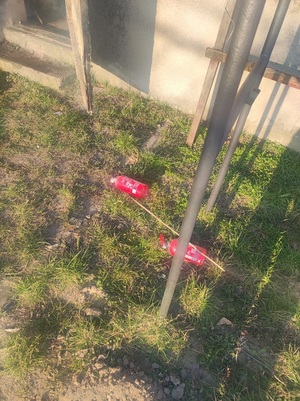dwie gaśnice leżące na trawie