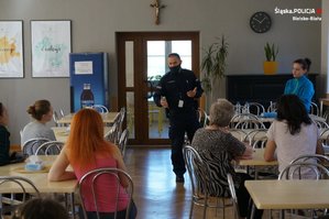 Policjant w stołówce pensjonatu prowadzi prelekcję z kobietami z Ukrainy
