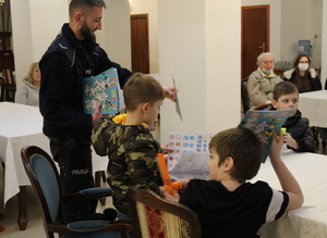 policjant rozdaje książeczki