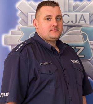 umundurowany policjant pozuje do zdjęcia