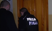 policjanci przed drzwiami wejściowymi do mieszkania starszej kobiety