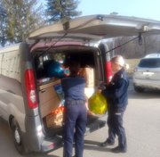 policjanci pakują do bagażnika radiowozu paczki dla uchodźców z Ukrainy