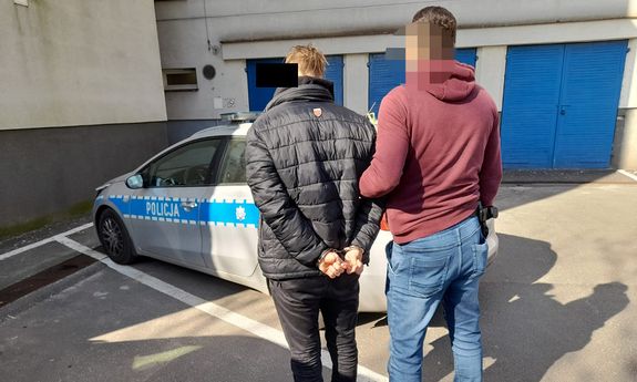 policjant prowadzi zatrzymanego