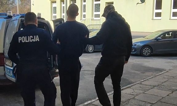 policjanci prowadzą zatrzymanego mężczyznę