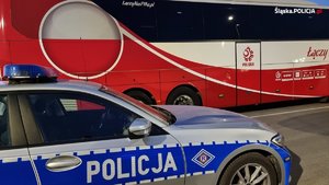 policyjny radiowóz na tle autokaru piłkarskiej reprezentacji Polski