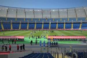 Widoczny stadion: część trybun i murawy oraz zawodnicy