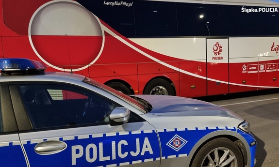 policyjny radiowóz na tle autokaru piłkarskiej reprezentacji Polski