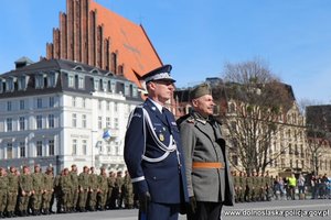 komendant wojewódzki Policji we Wrocławiu stoi na placu z mężczyzną ubranym w stój wojskowy z czasów II wojny światowej