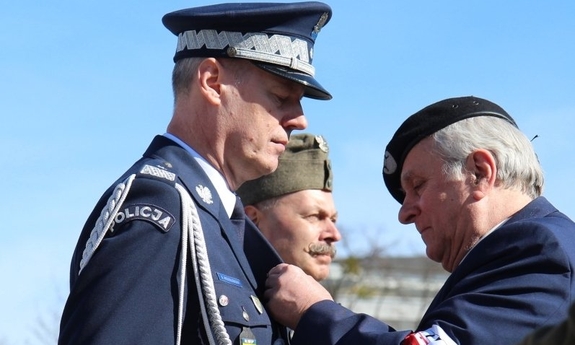 mężczyzna przypina odznaczenie komendantowi wojewódzkiemu Policji we Wrocławiu