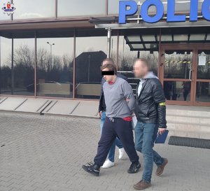 Zatrzymany prowadzony przez dwóch policjantów