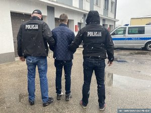 dwaj policjanci z zatrzymanym mężczyzną