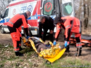 służby ratownicze przykrywają mężczyznę kocem termicznym, w tle karetka pogotowia