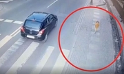 dziewczynka idzie chodnikiem, obok jedzie samochód