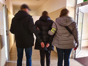 policjanci z zatrzymanym mężczyzną w kajdankach